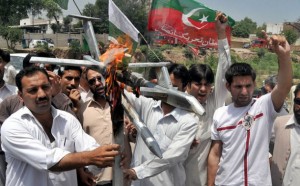 Members of Pakistan Tehreek-e-Insaf (PTI) party burn replica of Drone aircraft near Peshawar Press Club on May 14, 2011. Credit: Ashfaq Yusufzai/IPS