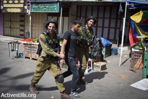 Israeli soldiers arrest a Palestinian youth.